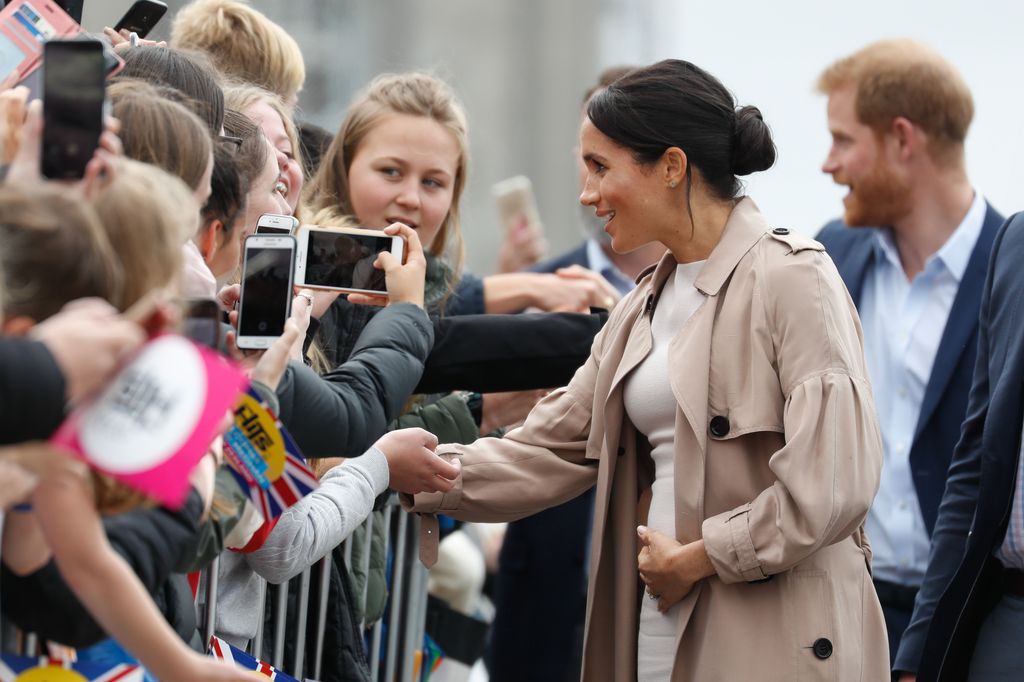 Meghan, Duchess of Sussex meeting fans and holding baby bump on the street during 'Walkabout' on October 30, 2018 in Auckland, New Zealand