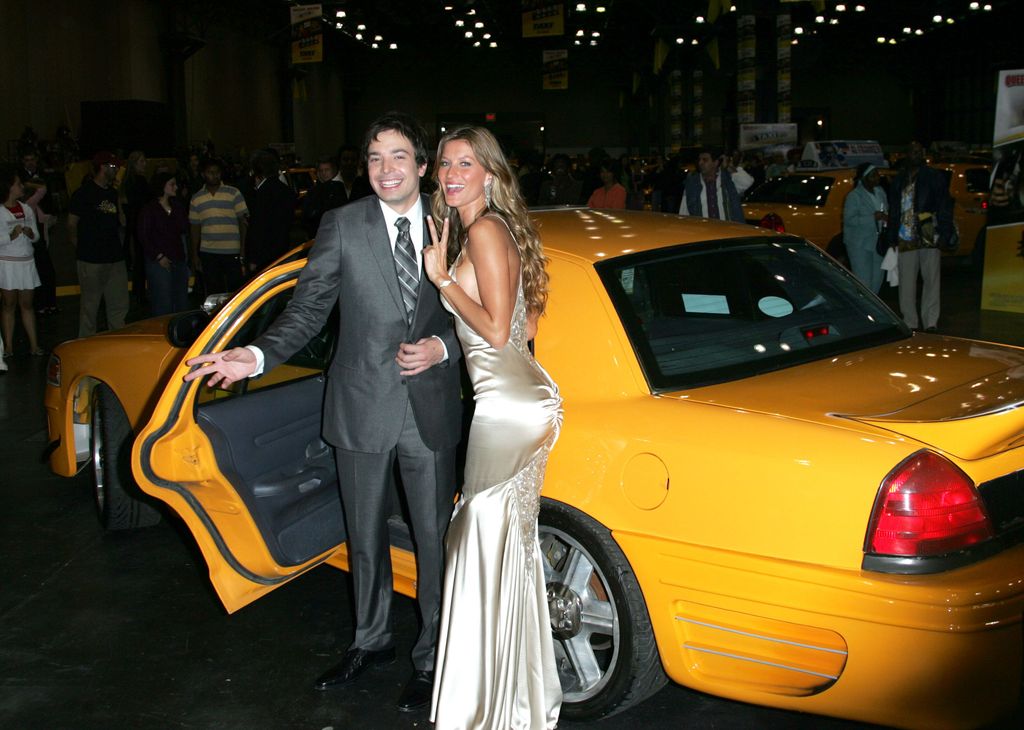 Jimmy Fallon and Gisele Bundchen in front of a yellow taxi at a film premiere