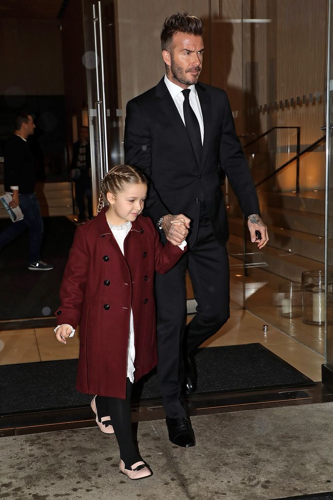 Harper wore a maroon coat with braids, holding hands with David Beckham in a black suit. Her rich-colored coat added sophistication to their father-daughter evening out.