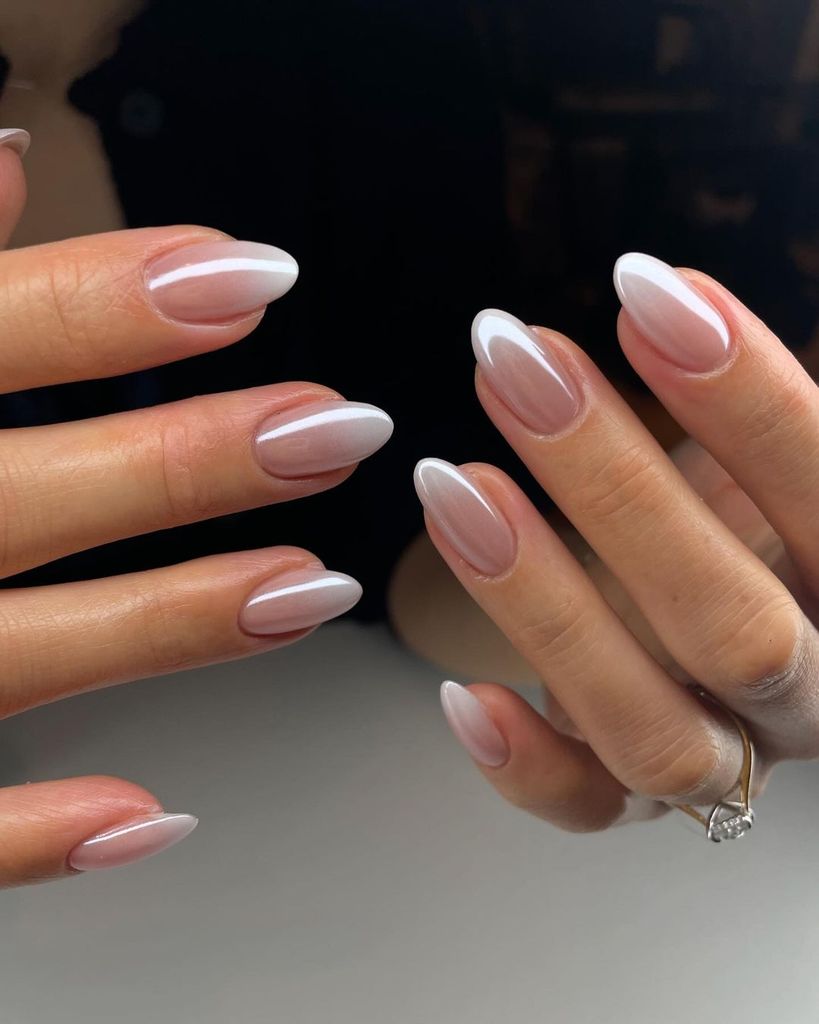 Almond-shaped nails with a soft, gradual ombre effect from natural pink to milky white tips, embodying a classic, elegant look with a modern twist, ideal for understated sophistication.