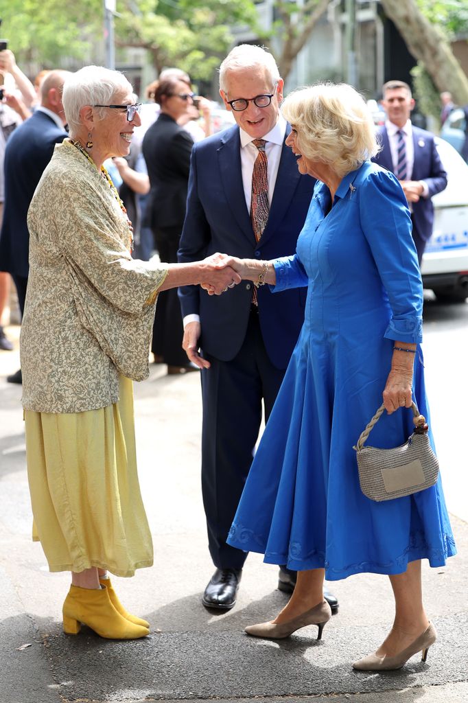 Queen Camilla is greeted by Ronni Kahn, OzHarvest Founder and Simeon Beckett ahead of her visit to Refettorio OzHarvest