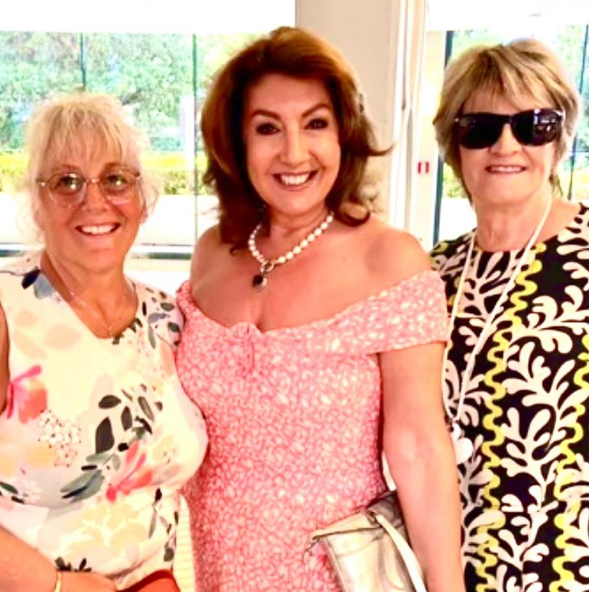 Jane McDonald in pink off-the-shoulder dress with two friend