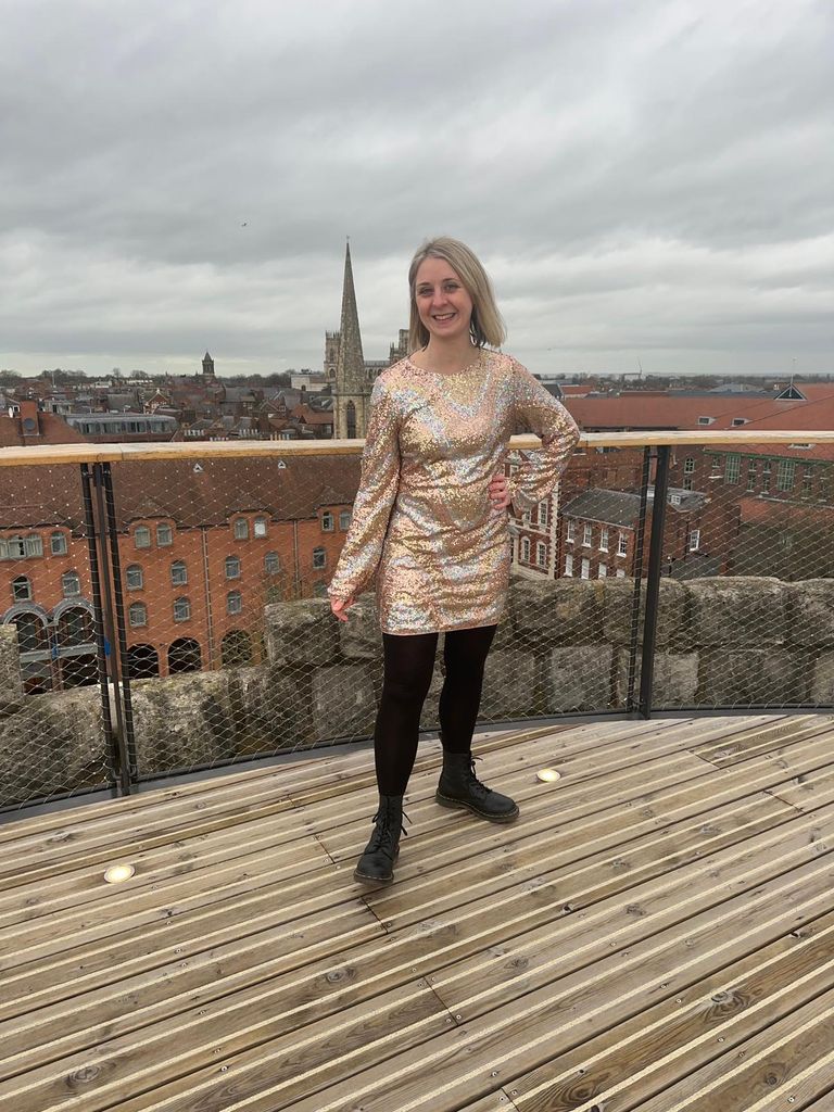 Lady on a rooftop in a sparkly dress