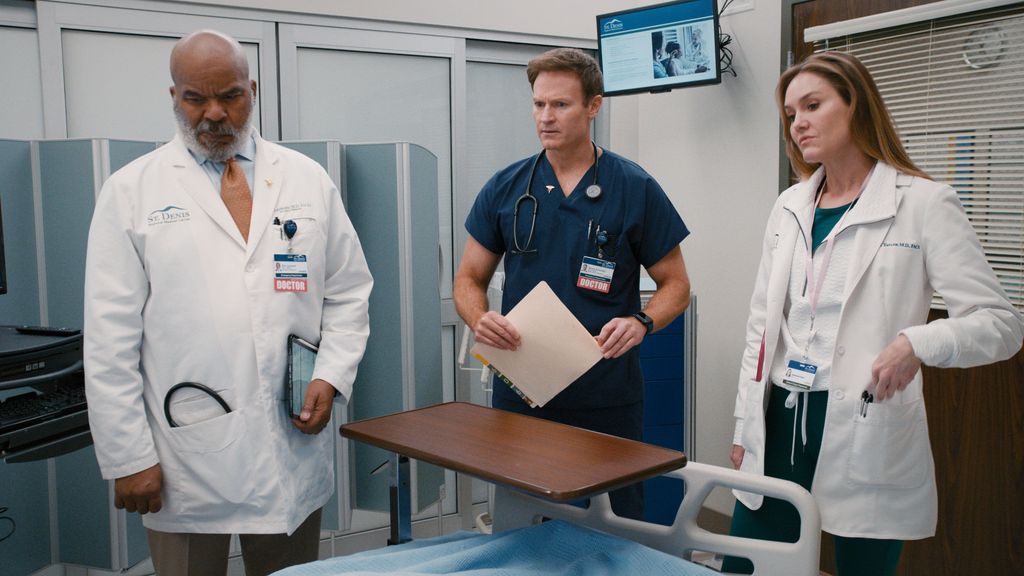 group of doctors standing around patient's hospital bed