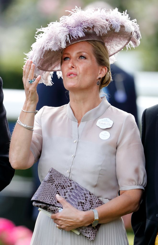 Sophie in feathered hat and mauve dress