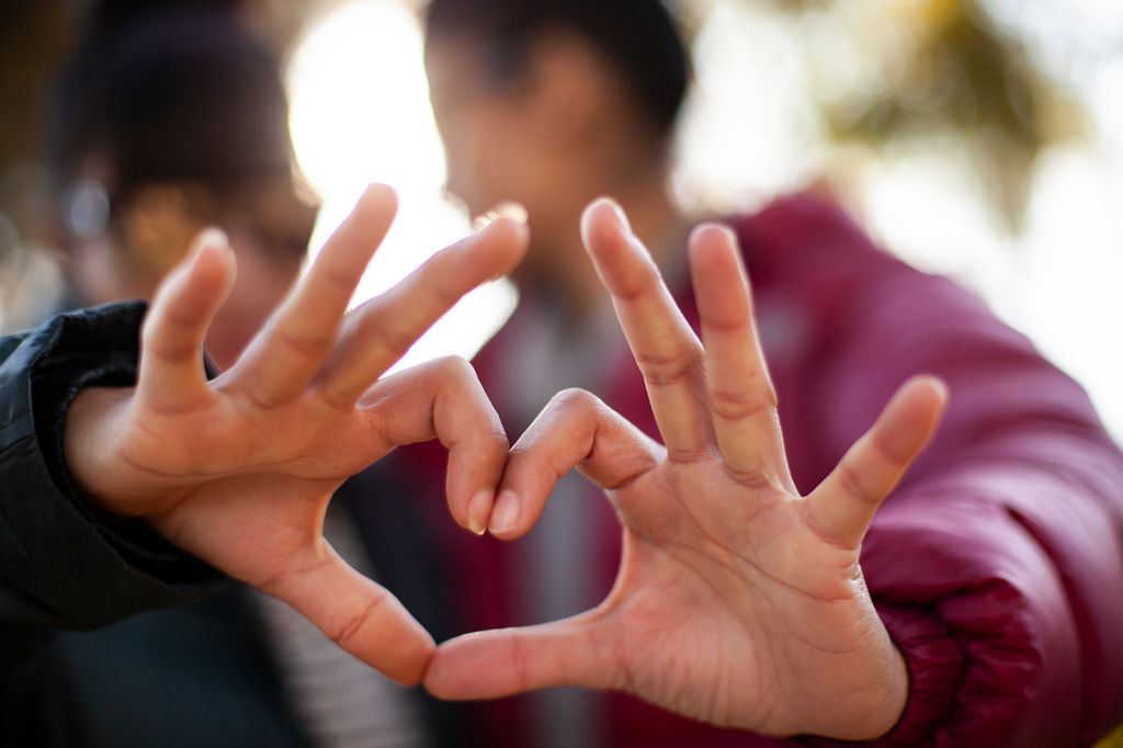 couple making heart with hands.