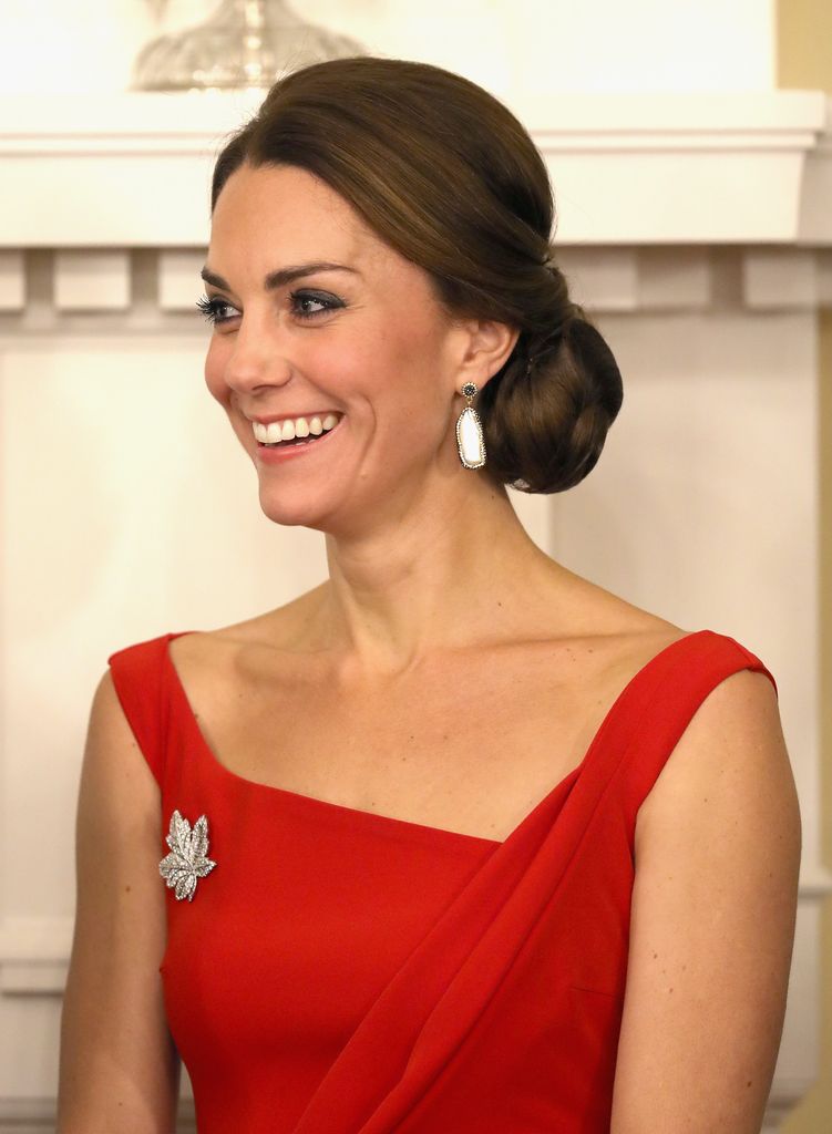 Kate with hair in low bun wearing red dress