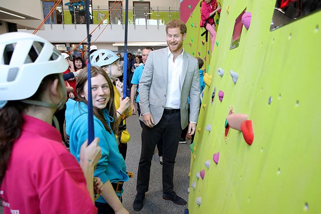 prince harry next to indoor climbing wall