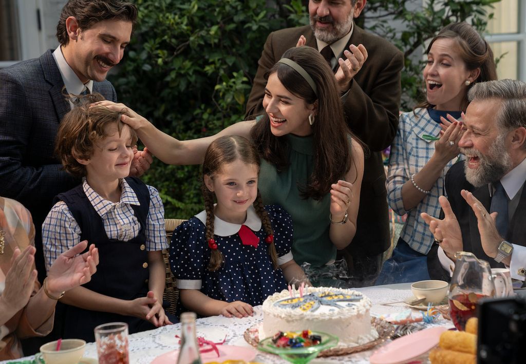 family gathered around girl in front of birthday cake