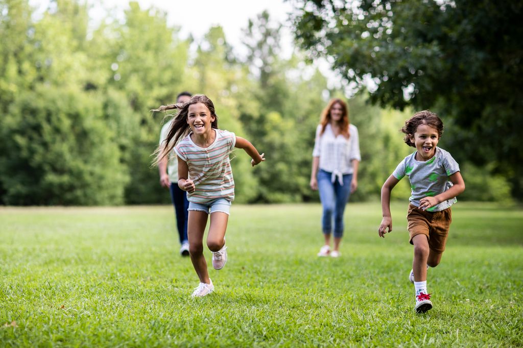Brother and sister running in the park