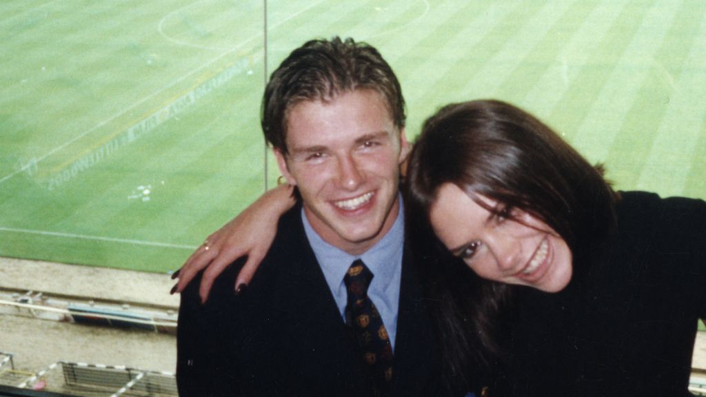 Victoria Beckham with her arm around David Beckham
