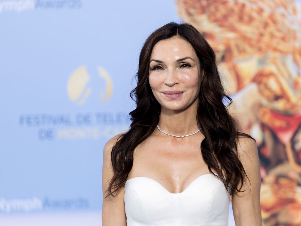 Famke wearing a white dress, long black hair, smiling