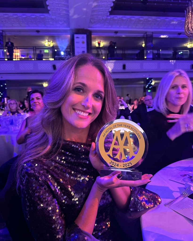 woman in sequin dress holding glass award