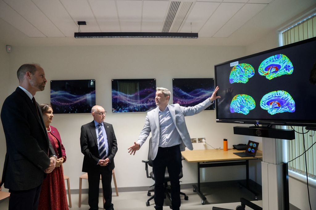 William stands with Dr. Agam Jung, as he meets clinical researchers in the tech room during a visit to the Rob Burrow Centre for Motor Neurone Disease, 