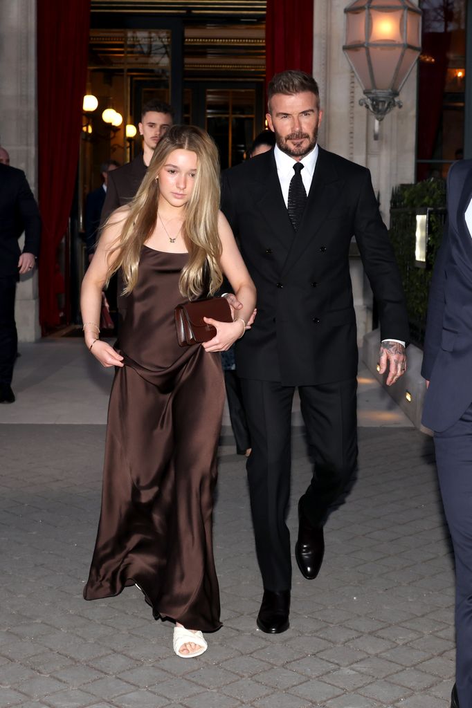 Harper Beckham walking with David Beckham holding her arm