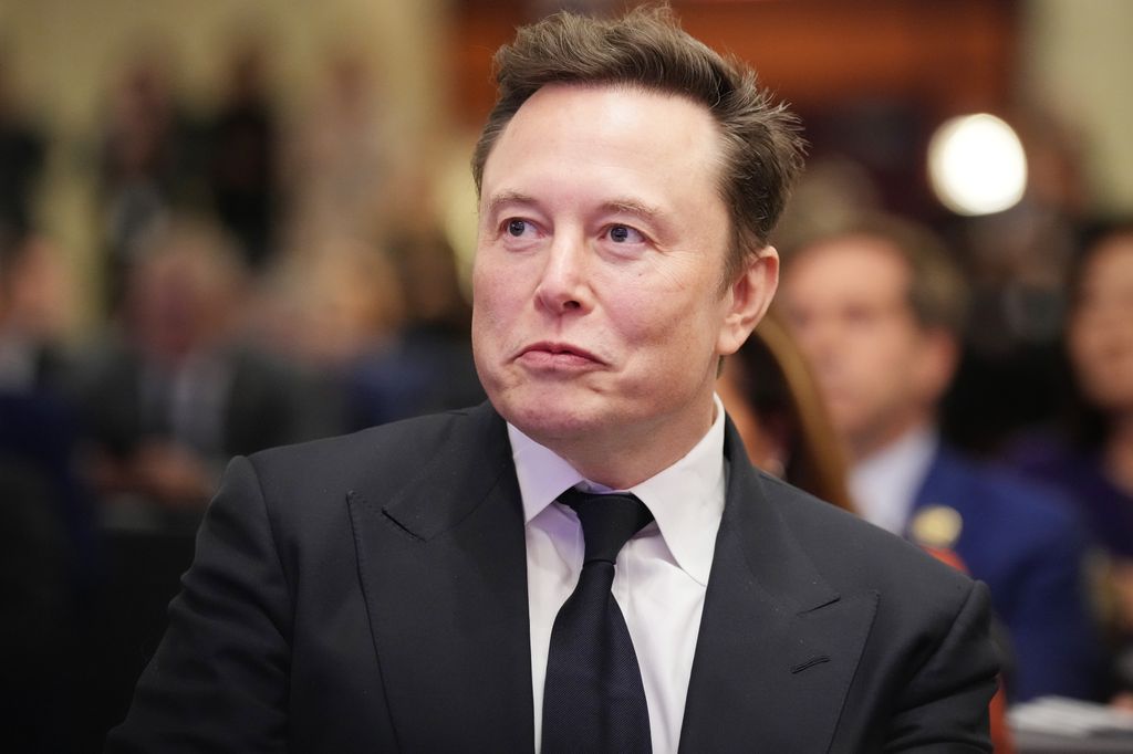 on Musk listens as U.S. President-elect Donald Trump addresses a House Republicans Conference meeting