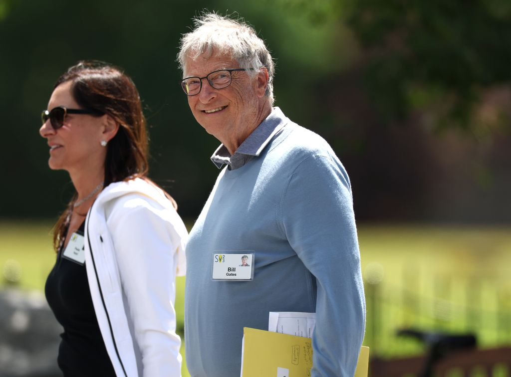 Bill Gates smiling walking next to Paula Hurd