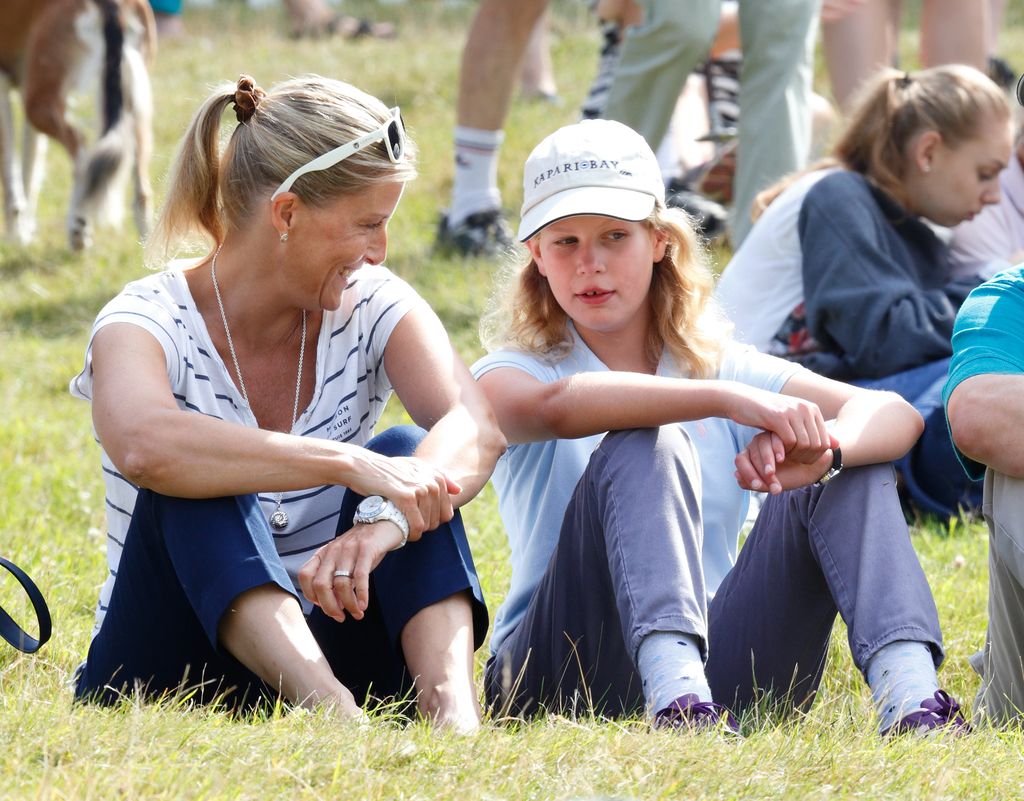 Lady Louise sat on floor in baseball cap with mum sophie