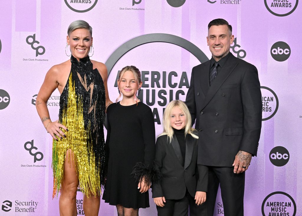 Pink standing with Carey Hart and their two children