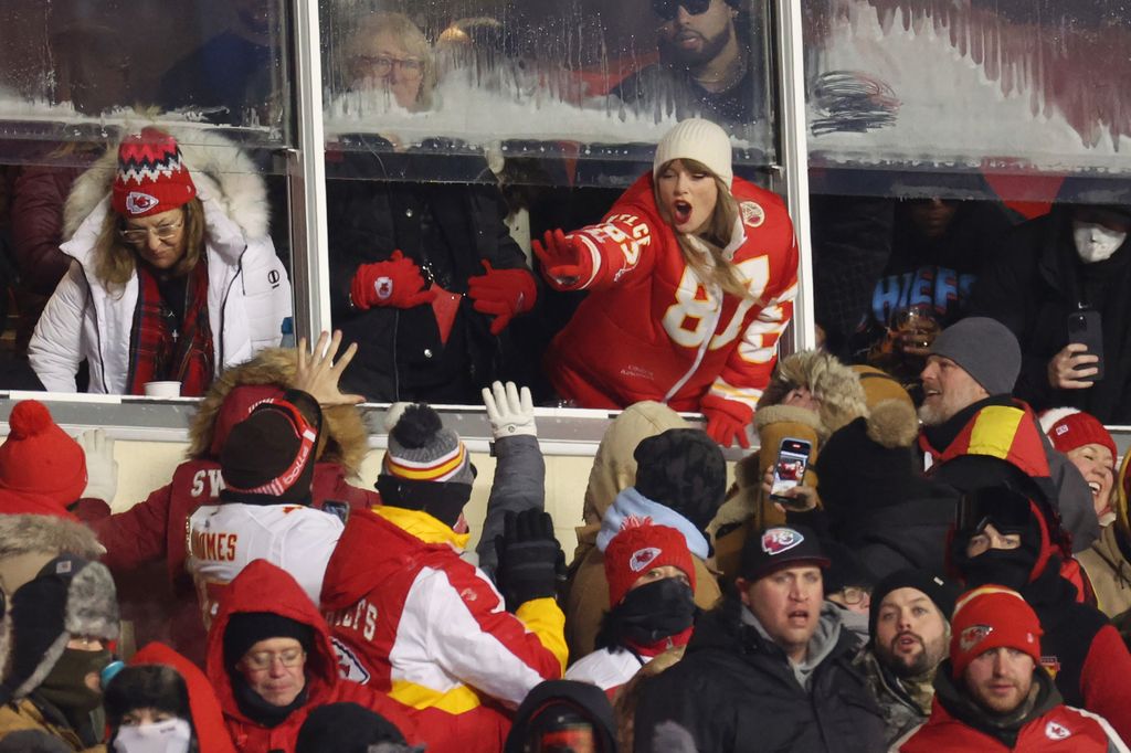 Taylor Swift celebrates with fans during the AFC Wild Card Playoffs between the Miami Dolphins and the Kansas City Chiefs at GEHA Field at Arrowhead Stadium on January 13, 2024 