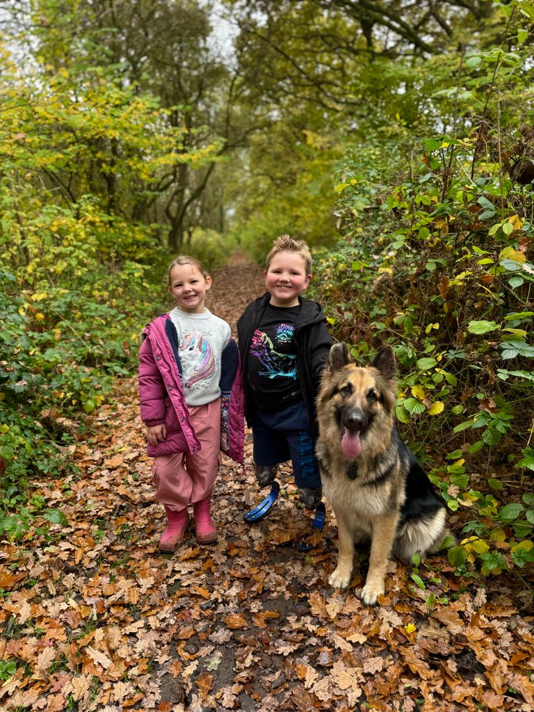 brother and sister outside with dog 