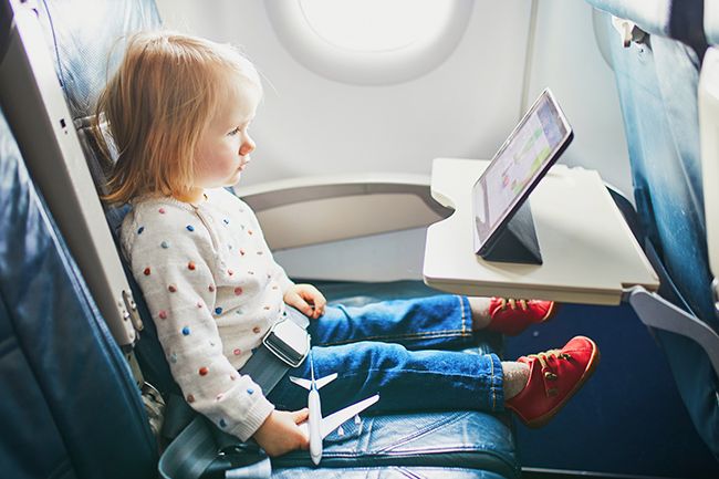 toddler watching screen on plane