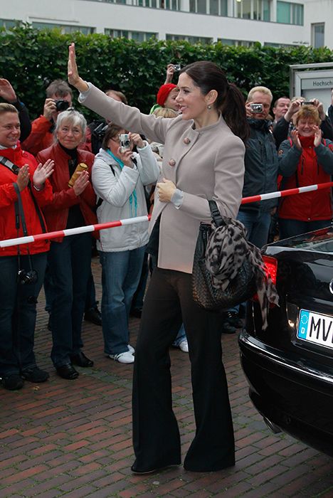 Crown Princess Mary of Denmark places a hand on her baby bump