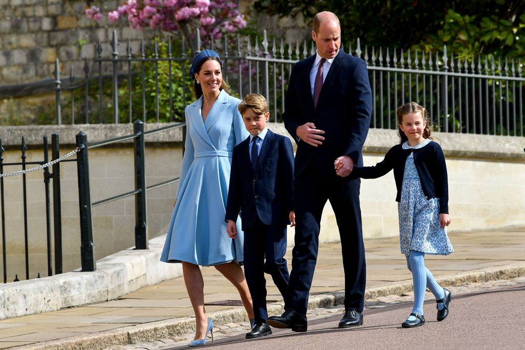 Prince William frowning and looking at Princess Charlotte