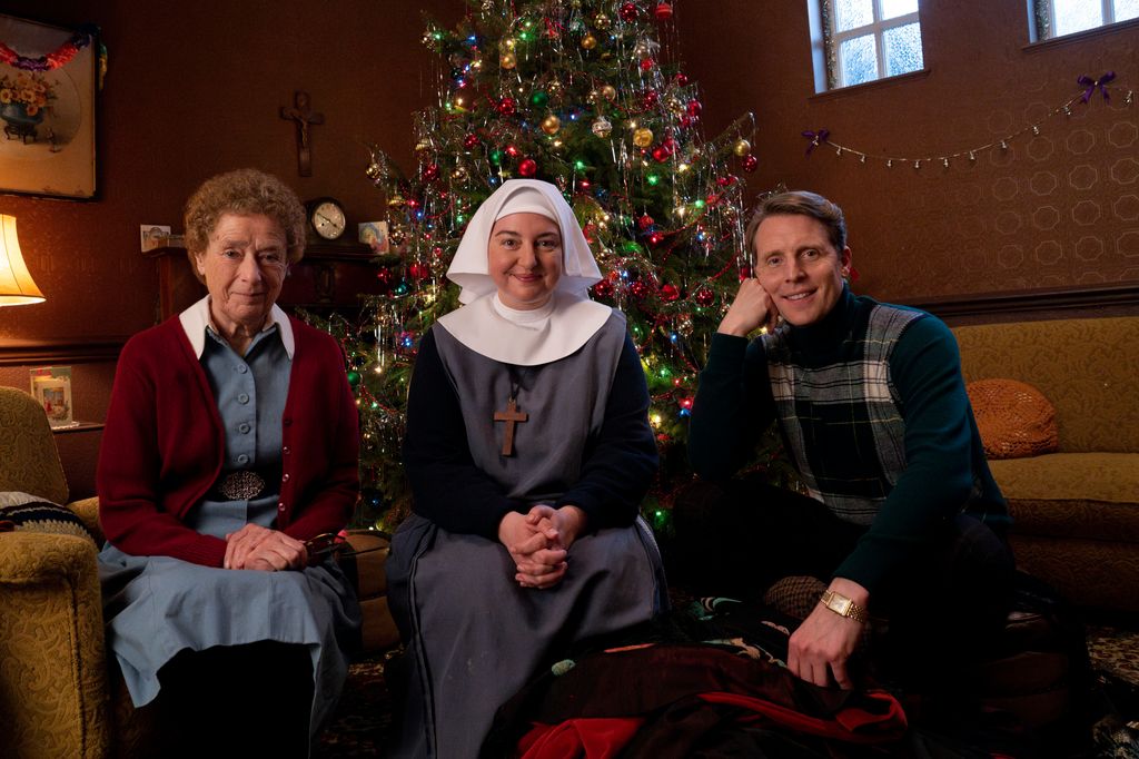 Three people sitting in front of Christmas tree