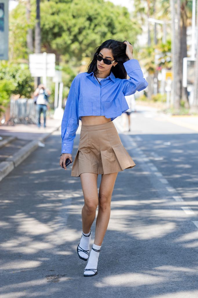 Sumita Bhandari wore a blue cropped button shirt, with a brown mini skirt, socks and heels