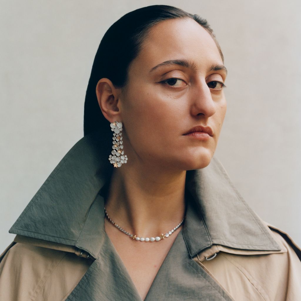 Model wearing hanging earrings by 886 by The Royal Mint