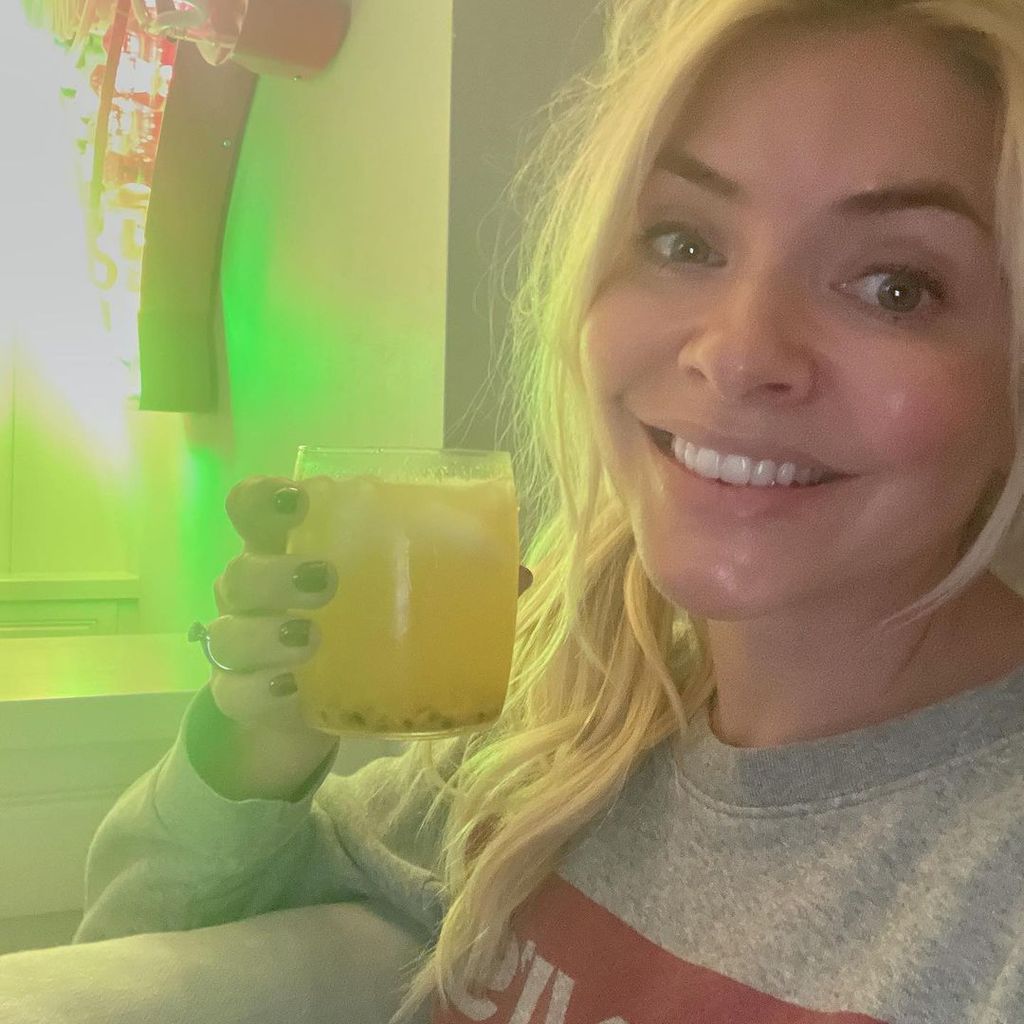 Holly Willoughby smiles as she holds up cocktail in selfie