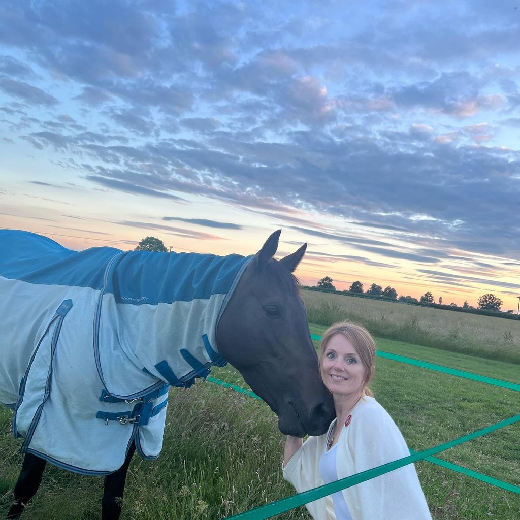 Geri Halliwell hugging a horse posing in field