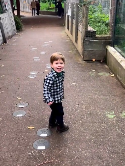 Princess Eugenie's eldest son August smiles as he walks through zoo