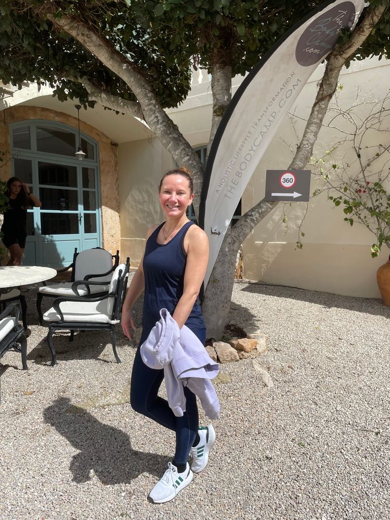 woman standing outside smiling in fitness clothes