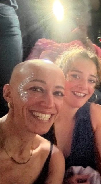 Two women smiling with glitter on their faces