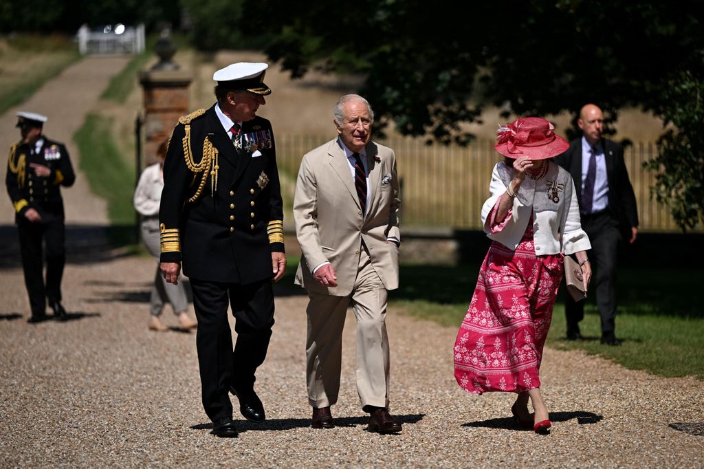 King Charles walking alongside two people