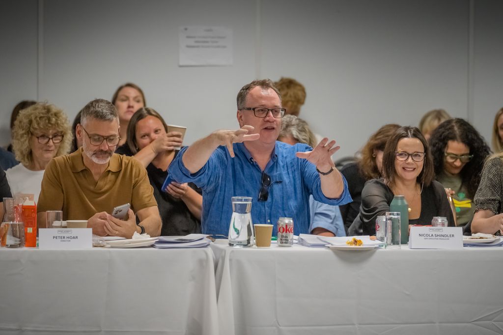 man sitting at white table surrounded by people