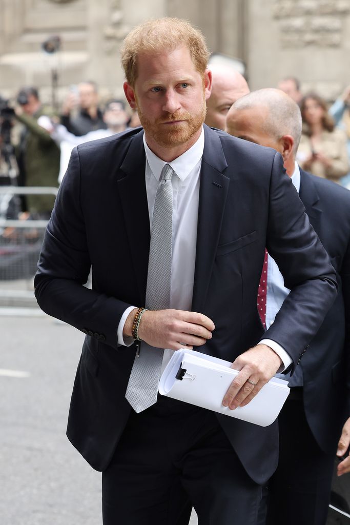 Prince Harry with paperwork outside court 