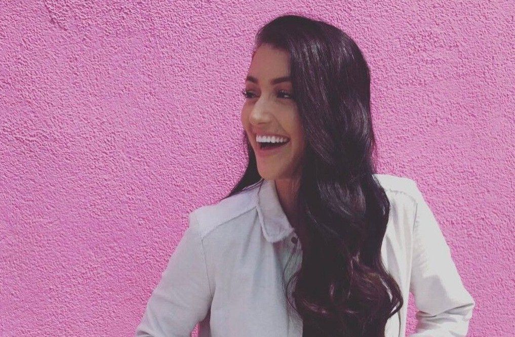 kailin nowak smiling against pink wall