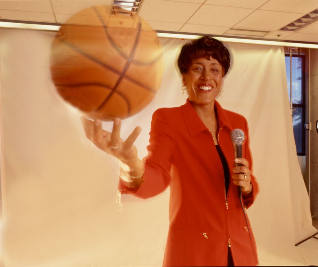 Robin Roberts as she poses with a basketball in one hand and a microphone in the other, New York, New York, 1990s