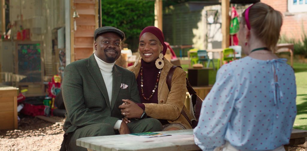 two people sitting at table holding hands