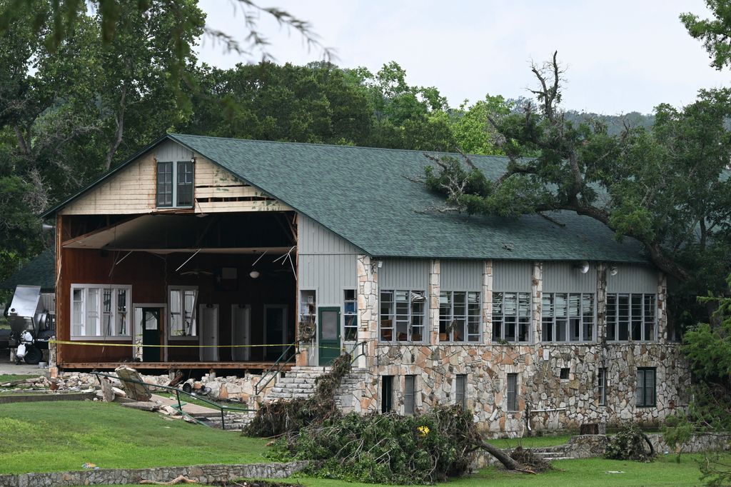 A view of damaged buildings and fallen trees at Camp Mystic along the Guadalupe River in Hunt, Texas, on July 7, 2025, following severe flash flooding that occurred during the July 4 holiday weekend. Rescuers in Texas continue to race against time to find dozens of missing people, including children, swept away by flash floods that killed more than 80 people, with forecasters warning of new deluges. In a terrifying display of nature's power, the rain-swollen waters of the Guadalupe River reached treetops and the roofs of cabins in Camp Mystic as girls slept overnight on Friday, July 4, washing away some of them and leaving a scene of devastation