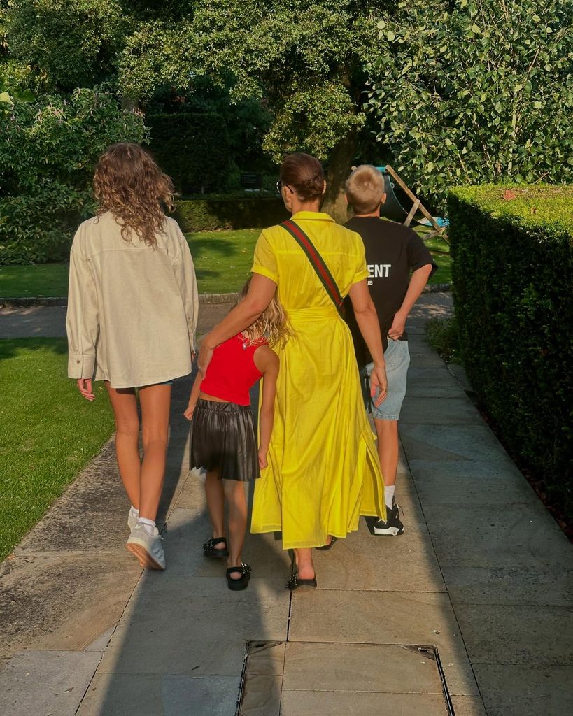 Emma Willis walking away from the camera with her three kids 