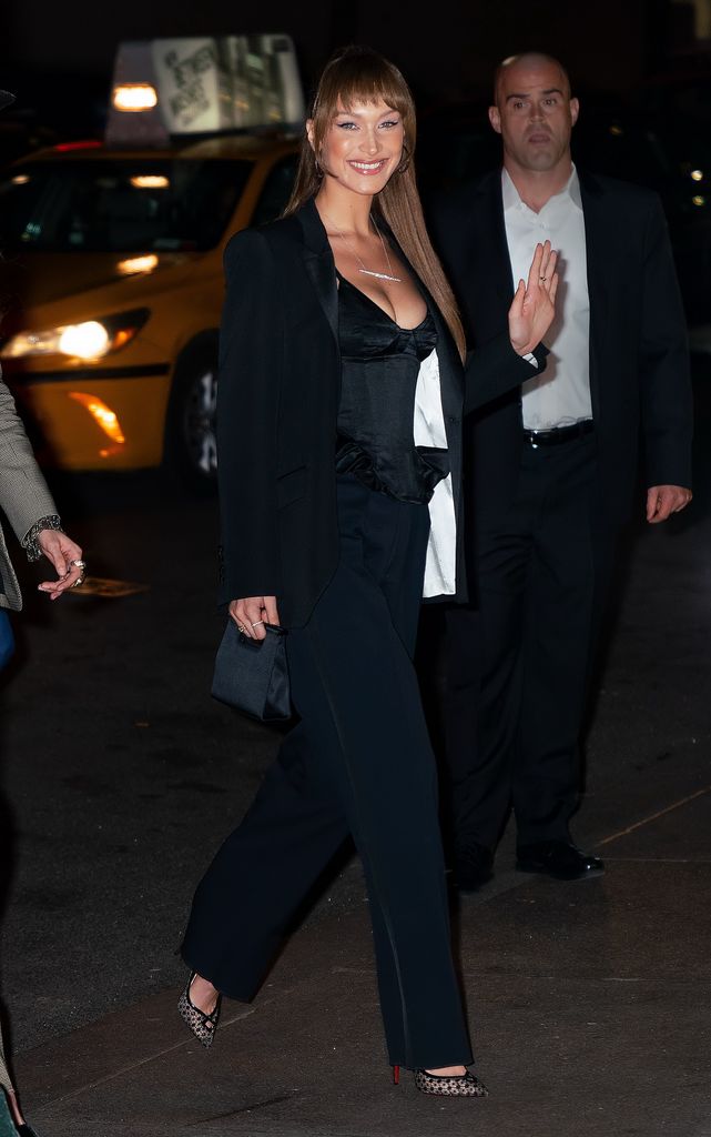 Bella Hadid smiling in black suit 