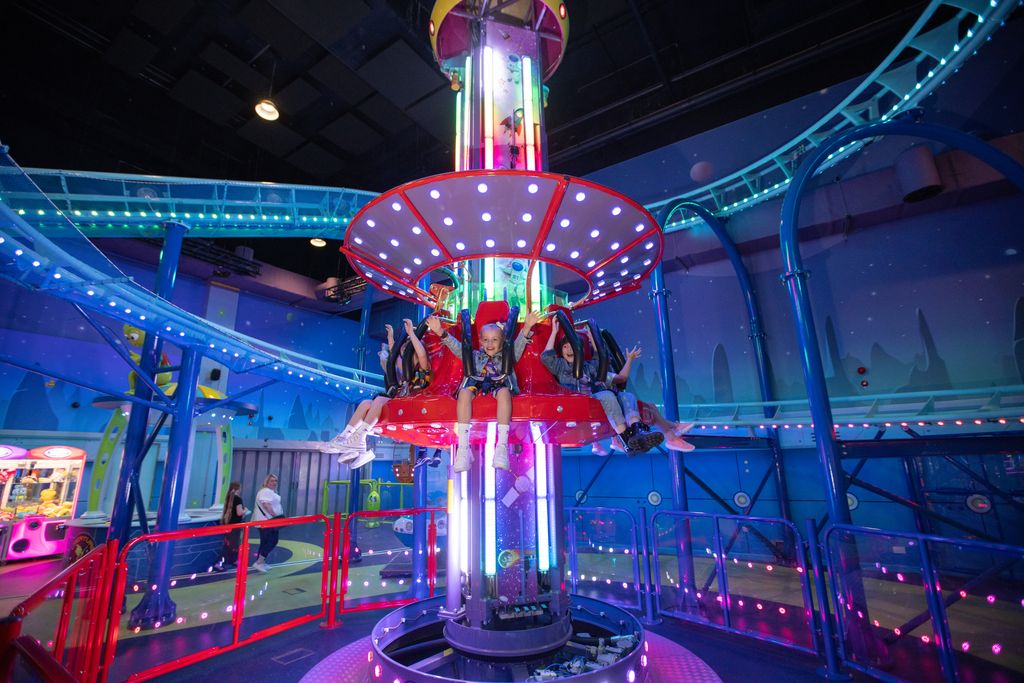 A group of children ride a spinning drop tower ride inside babylon park in Camden, London