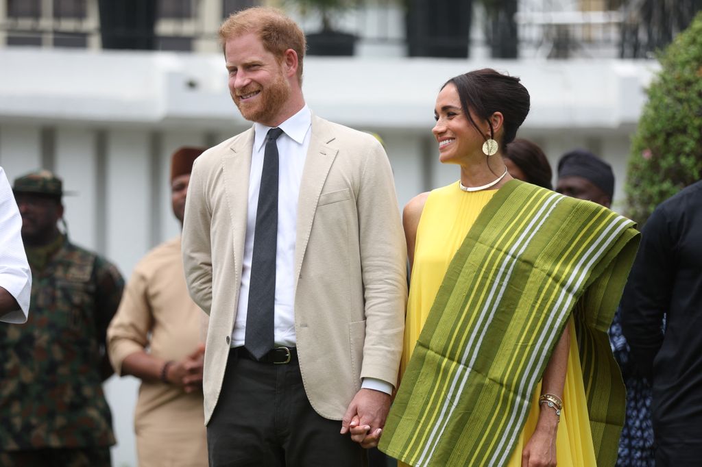 Britain's Prince Harry (2ndR), Duke of Sussex, and  Britain's Meghan (R), Duchess of Sussex, react as Lagos State Governor, Babajide Sanwo-Olu (unseen), gives a speech at the State Governor House in Lagos 