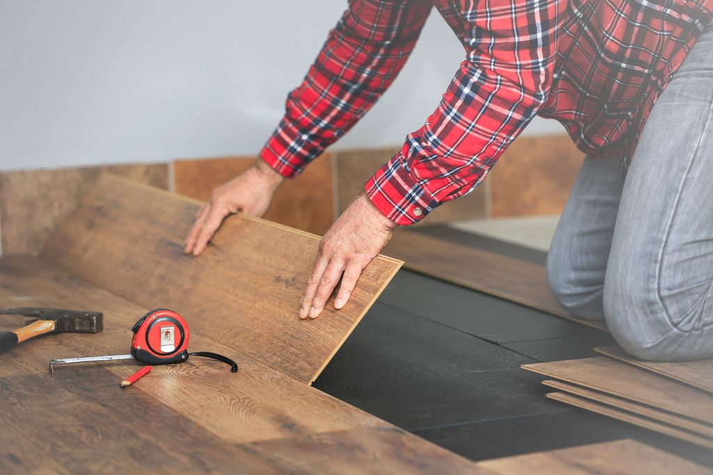 person laying wooden flooring 