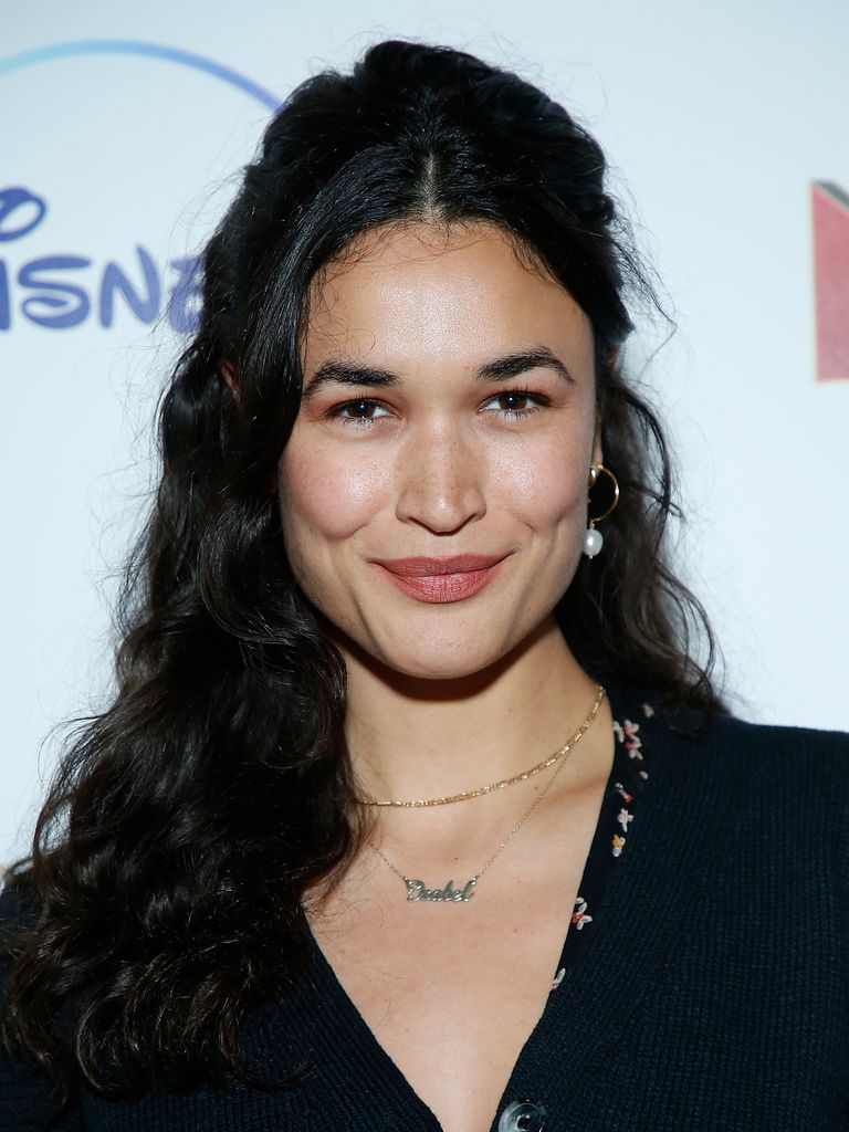 Scarlett porte ses longs cheveux noirs et sourit à la caméra.