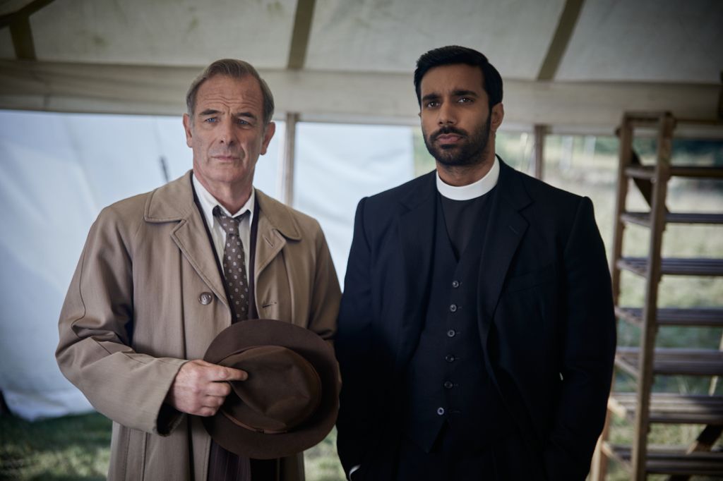man in trench coat next to vicar
